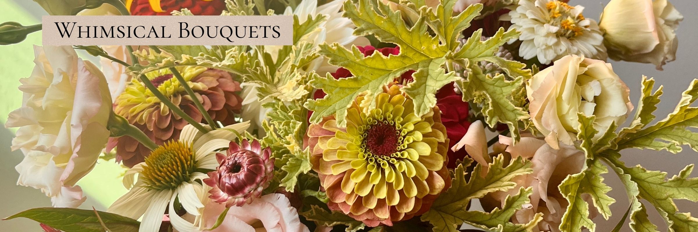 Close-up of a bouquet with zinnias and lisianthus in blush and red tones